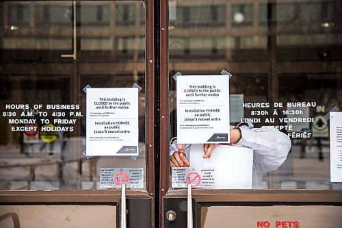 MIKAELA MACKENZIE / WINNIPEG FREE PRESS

A security guard puts up signs announcing the closure of City Hall to the general public in Winnipeg on Friday, April 3, 2020. For Joyanne story.
Winnipeg Free Press 2020