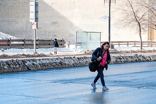Daniel Crump / Winnipeg Free Press. A woman jaywalks to cross Main Street just north of the Portage and Main intersection. The city has decided to close the skywalk system and the concourse at Portage and Main for health reasons. April 4, 2020.