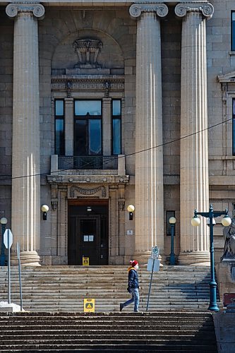 MIKE DEAL / WINNIPEG FREE PRESS
A person wearing a mask walks past the Manitoba Legislative Building Tuesday afternoon.
200407 - Tuesday, April 07, 2020.