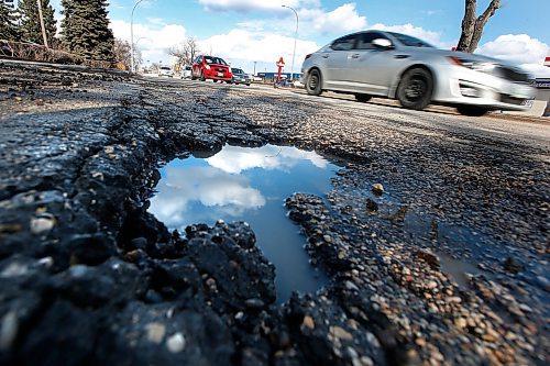 JOHN WOODS / WINNIPEG FREE PRESS
Cars pass a pothole on Henderson in Winnipeg Wednesday, April 8, 2020. 

Reporter: ?