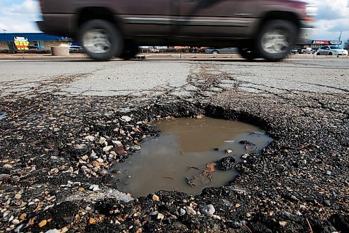 JOHN WOODS / WINNIPEG FREE PRESS
Cars pass a pothole on Henderson in Winnipeg Wednesday, April 8, 2020. 

Reporter: ?