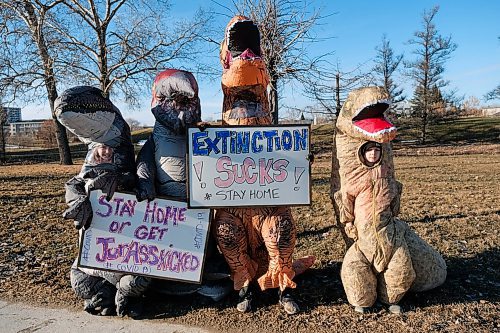 Daniel Crump / Winnipeg Free Press. Nicole Esch (middle left) and her four kids, all dressed like dinosaurs, walk along Portage Avenue carrying signs that encourage people to stay home. Esch, an emergency room nurse at Winnipegs Health Sciences Centre, says her and her kids got their dino costumes for halloween and thought this would be a fun and useful way to use them again. April 10, 2020.
