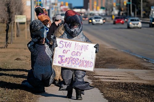 Daniel Crump / Winnipeg Free Press. Nicole Esch (middle) and her four kids, all dressed like dinosaurs, walk along Portage Avenue carrying signs that encourage people to stay home. Esch, an emergency room nurse at Winnipegs Health Sciences Centre, says her and her kids got their dino costumes for halloween and thought this would be a fun and useful way to use them again. April 10, 2020.