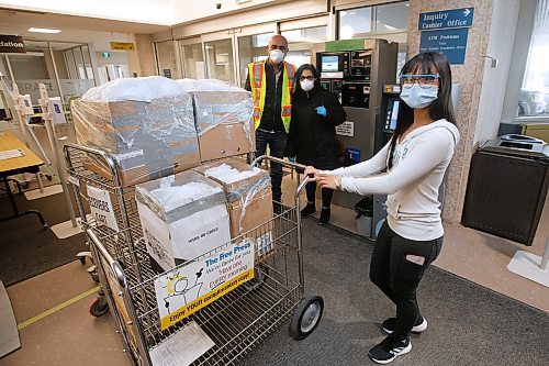 JOHN WOODS / WINNIPEG FREE PRESS
A healthcare worker moves food Maysoun Darweesh and Nour Ali, background, of the Kurdish Initiative for Refugees dropped off for the staff Grace Hospital in Winnipeg Monday, April 13, 2020. This gesture is part of the project called From Our Kitchens To Our Heros where community organizations, Chinese, and Asian restaurants are uniting to provide 50 meals each night to 50 front-line health workers fighting COVID-19.

Reporter: ?