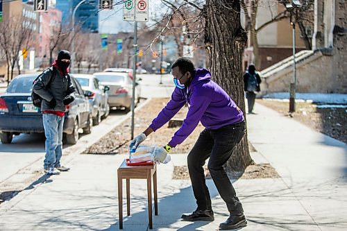 MIKAELA MACKENZIE / WINNIPEG FREE PRESS

Community organizer Raymond Ngabou serves up free lunch to Chris Bo while practising social distancing at Knox Church in Winnipeg on Wednesday, April 15, 2020. For Brenda Suderman story.
Winnipeg Free Press 2020