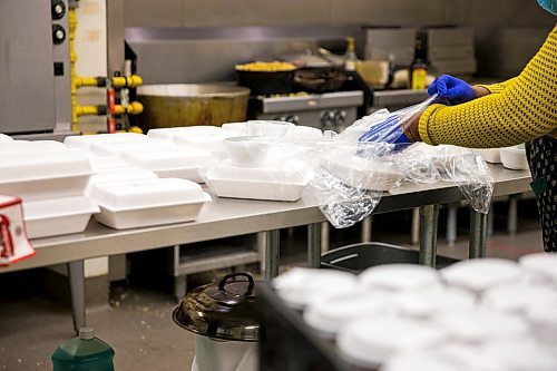 MIKAELA MACKENZIE / WINNIPEG FREE PRESS

Melrose Koineh packages up free lunches at the Knox Church community kitchen in Winnipeg on Wednesday, April 15, 2020. For Brenda Suderman story.
Winnipeg Free Press 2020