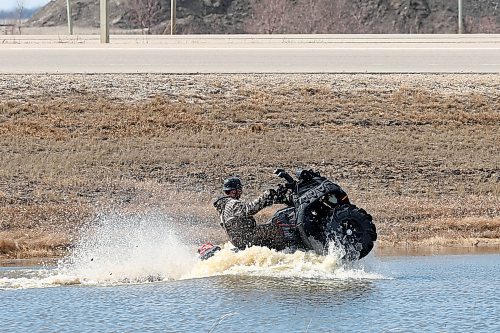SHANNON VANRAES / WINNIPEG FREE PRESS
Curtis Charzewski takes advantage of some overland flooding along Highway 75 to put his ATV through its paces on April 17, 2020.