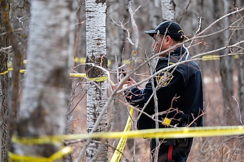 Daniel Crump / Winnipeg Free Press. A Winnipeg Police Service officer tapes off an area in Assiniboine Forrest. Police are investigating after bones were discovered. April 18, 2020.