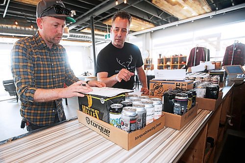 JOHN WOODS / WINNIPEG FREE PRESS
Ben Sigurdson, left, Winnipeg Free Press writer, organizes the daily delivery order with John Heim of Torque Brewing Co. in Winnipeg Wednesday, April 22, 2020. COVID-19 has shutdown on-site serving in bars and restaurants and some local brew companies have been delivering their goods to their customers homes. Sigurdson took to the streets and delivered Torques daily order.

Reporter: Sigurdson