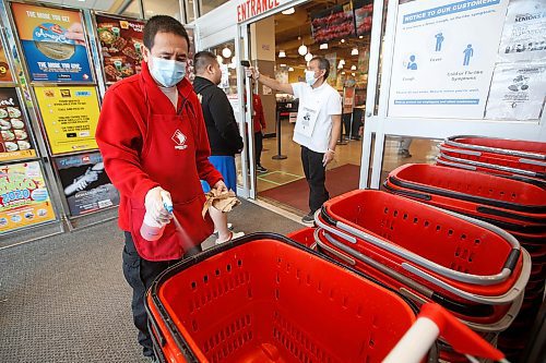 JOHN WOODS / WINNIPEG FREE PRESS
Ronald Napiza disinfects baskets as Edwin Mendoza takes temperatures at Seafood City in Winnipeg Thursday, April 23, 2020. Seafood City have taken great steps to ensure the safety of their customers and staff.

Reporter: Abas