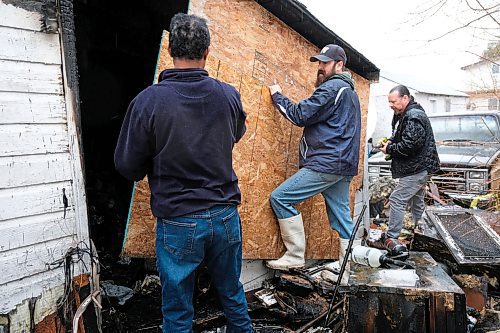Daniel Crump / Winnipeg Free Press. Vern Seidlikoski (middle) and other neighbours help board-up Chris Penners burned out house Saturday afternoon. Penner lost his 33 year residence to fire Saturday afternoon. April 25, 2020.