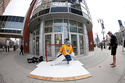 JOHN WOODS / WINNIPEG FREE PRESS
College goaltender Travis Ridgen takes shot from his coach Guy St Vincent in front of a downtown arena Monday, April 27, 2020. Ridgen wanted a little practice and footage for his video channel so what better way than on synthetic ice in front of the home of the Winnipeg Jets.

Reporter: Sawatzky