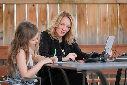 RUTH BONNEVILLE  /  WINNIPEG FREE PRESS 

local - VIRUS TEACHER STRESS

Photo of Grade 6-7 math teacher Cori Wiebe with her daughter Eva (8yrs), working on homework on their deck. 

A teacher of 20 years, Grade 6-7 math teacher Cori Wiebe has pivoted online and learned lots of new educational software and how to use it with her students throughout the last few weeks. She says it's been stressful, but she's tackling things day by day with a structured daily schedule and Microsoft Teams video calls with her classes. She really misses the in-person interactions with her students - so much so, she broke down in tears during a phone call this afternoon.  

April 27th,  2020
