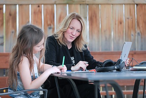 RUTH BONNEVILLE  /  WINNIPEG FREE PRESS 

local - VIRUS TEACHER STRESS

Photo of Grade 6-7 math teacher Cori Wiebe with her daughter Eva (8yrs), working on homework on their deck. 

A teacher of 20 years, Grade 6-7 math teacher Cori Wiebe has pivoted online and learned lots of new educational software and how to use it with her students throughout the last few weeks. She says it's been stressful, but she's tackling things day by day with a structured daily schedule and Microsoft Teams video calls with her classes. She really misses the in-person interactions with her students - so much so, she broke down in tears during a phone call this afternoon.  

April 27th,  2020

