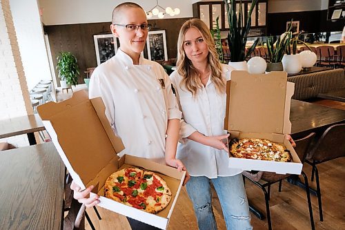 Daniel Crump / Winnipeg Free Press. Pizzeria Gustos Chef Connie Klassen (left) and owner Amanda McGrath hold pizzas as they stand for photos in their Academy Avenue restaurant. April 30, 2020.