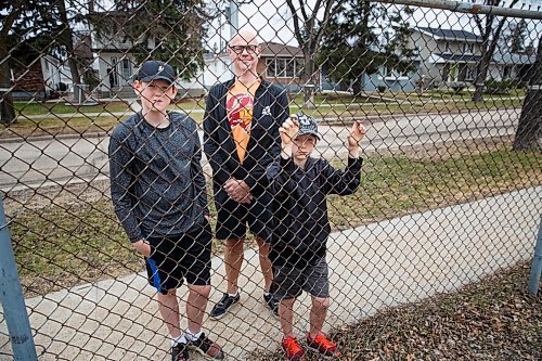 MIKE DEAL / WINNIPEG FREE PRESS
Darren Thomas a risk manager for Manitoba School Boards Association, with his sons, Carson, 12, and Owen, 8, looking longingly at Montrose School playground equipment which they will not be able to use Monday when the province makes it allowable. 
Thomas said theres too  much risk and liability to reopen school playgrounds right now. They wont reopen until they get clear guidance from public health or the return of laid-off maintenance staff who can make sure the equipment is safe, never mind disinfected.
See Carol Sanders story
200501 - Friday, May 01, 2020.