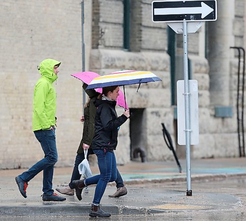 SHANNON VANRAES / WINNIPEG FREE PRESS
Pedestrians carrying umbrellas pass each other at the intersection of Adelaide Street and Bannatyne Avenue in Winnipeg's Exchange District on May 1, 2020.