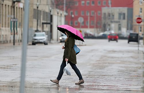 SHANNON VANRAES / WINNIPEG FREE PRESS
A pedestrian carrying a pink umbrella crosses the intersection at Adelaide Street and Bannatyne Avenue in Winnipeg's Exchange District on May 1, 2020.