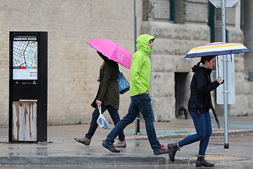 SHANNON VANRAES / WINNIPEG FREE PRESS
Pedestrians carrying umbrellas pass each other at the intersection of Adelaide Street and Bannatyne Avenue in Winnipeg's Exchange District on May 1, 2020.