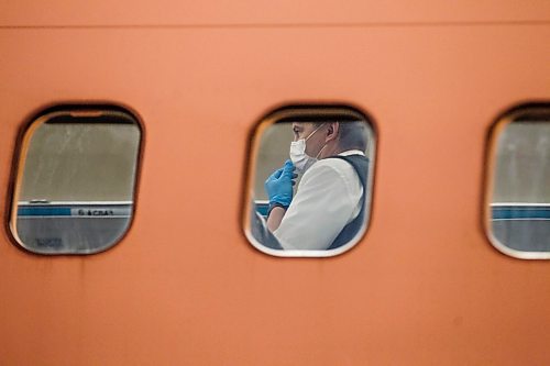 MIKE DEAL / WINNIPEG FREE PRESS
24-hr project - 4am
A crew member adjusts their mask during boarding of the 5:49am WestJet WS520 flight to Toronto. 
See Melissa Martin story
200506 - Wednesday, May 06, 2020.
