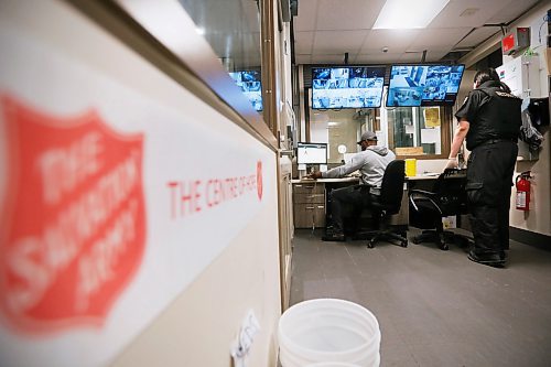 JOHN WOODS / WINNIPEG FREE PRESS
Contracted security officer Oliver Muswagon, right, checks his security camera screens as staff member Charles checks in a client at the Salvation Army in Winnipeg Wednesday, May 6, 2020. 

Reporter: Thorpe/Part of 24 hr life during COVID-19 project