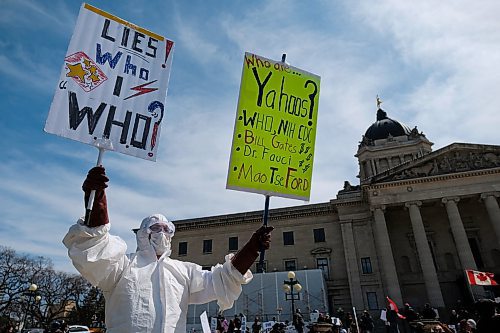 Daniel Crump / Winnipeg Free Press. An unidentified person holds signs during an anti-lockdown rally at the Manitoba Legislature. The event was hosted by a group called Winnipeg Aware People with a Passion for the Truth. May 9, 2020.