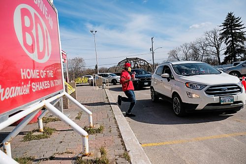 Daniel Crump / Winnipeg Free Press. A BDI employee carries an ice cream cone to a customers car. The ice cream shop is now open for business, but only as a drive thru. May 9, 2020.