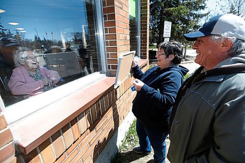 JOHN WOODS / WINNIPEG FREE PRESS
Keeping in mind COVID-19 distance protocols Simone and Gerry Syrenne writes You Look Good on a whiteboard as they visit Simones mother Henriette Bernardin, 94, at West Park Manor on Mothers Day in Winnipeg Sunday, May 10, 2020. 

Reporter: ?
