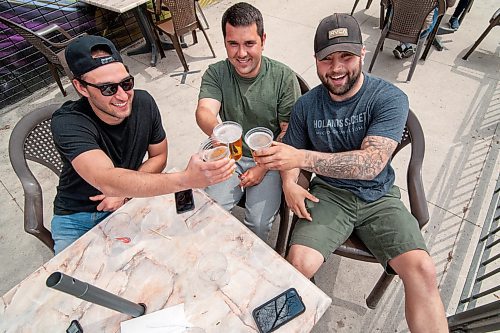 Mike Sudoma / Winnipeg Free Press
(Left to right) Tanner Garveline, Ryan Martins and Kasey Russell cheers their beers while hanging out on the patio at Bar Italia Saturday afternoon
May 16, 2020
