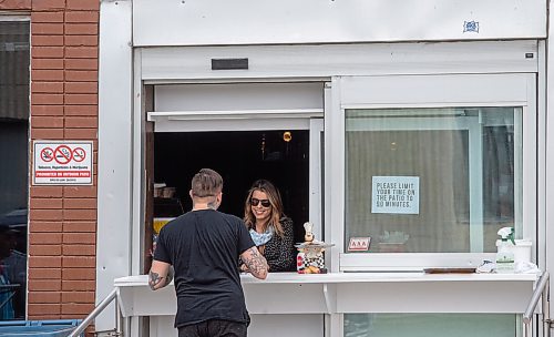Mike Sudoma / Winnipeg Free Press
A worker at Bar Italia serves a customer from their newly installed pickup window Saturday afternoon
May 16, 2020