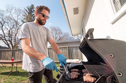 Mike Sudoma / Winnipeg Free Press
John Demedashe puts some burgers on the bbq Saturday evening in St James 
May 16, 2020