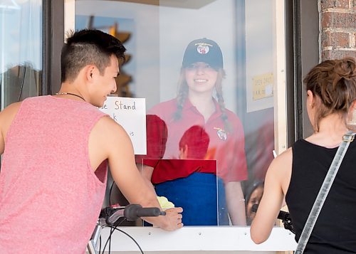 Mike Sudoma / Winnipeg Free Press
Shirel Finkelshtein hands her customers their orders through a delivery window as she works her shift at Sargeant Sundae Saturday afternoon
May 16, 2020