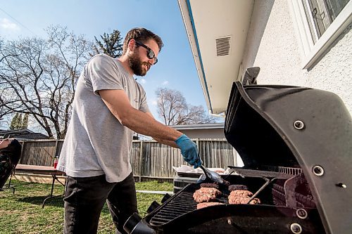 Mike Sudoma / Winnipeg Free Press
John Demedashe puts some burgers on the grill Saturday evening in St James 
May 16, 2020