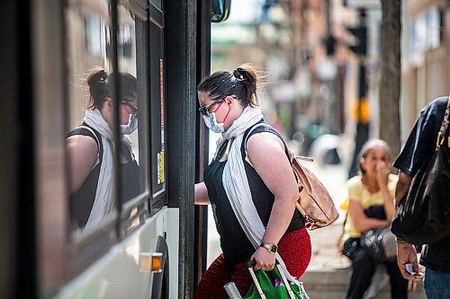 MIKAELA MACKENZIE / WINNIPEG FREE PRESS

Tiffany Elston wears a mask while getting on the bus downtown in Winnipeg on Tuesday, May 19, 2020. Councillor Jeff Browaty wants to require all Winnipeg Transit passengers wear face masks as a way to instill more confidence in riders as the economy reopens. For Joyanne story.
Winnipeg Free Press 2020.