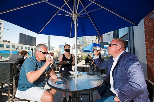 MIKE DEAL / WINNIPEG FREE PRESS
Paul Kuzina (left) and Michael Falk (right) with server Beth Popoff on the patio at the Earls on Main Street Wednesday afternoon.
See Bens story on top 5 patios
200520 - Wednesday, May 20, 2020.