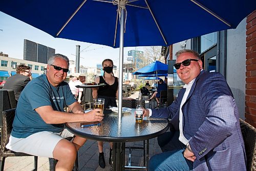 MIKE DEAL / WINNIPEG FREE PRESS
Paul Kuzina (left) and Michael Falk (right) with server Beth Popoff on the patio at the Earls on Main Street Wednesday afternoon.
See Bens story on top 5 patios
200520 - Wednesday, May 20, 2020.