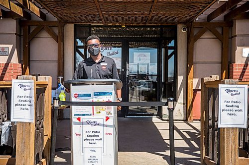 MIKAELA MACKENZIE / WINNIPEG FREE PRESS

Jalen Sewell, assistant duty manager, waits to let people in and sanitize their hands at the patio at Tavern United (Fort Garry location) in Winnipeg on Wednesday, May 20, 2020. For entertainment story.
Winnipeg Free Press 2020.