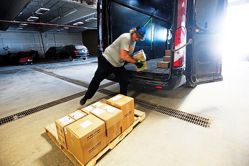 JOHN WOODS / WINNIPEG FREE PRESS
Mike Caners of Runnin Red, a cross border courier, unloads packages from Emerson in their warehouse in Winnipeg Wednesday, May 20, 2020. Runnin Red co-owner Trevor Froese says that currently they are probably doing four to five times the normal volume.

Reporter: Waldman