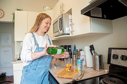 Mike Sudoma / Winnipeg Free Press
Elsa Taylor, head bartender and co-owner of The Roost, pours some gin as she makes her Amped up Gin and Soda in her apartment Saturday afternoon
May 23, 2020