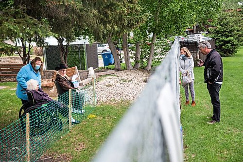 MIKAELA MACKENZIE / WINNIPEG FREE PRESS

Cheryl Hedlund and Chris Siddorn visit Cheryl's parents, Ron and Anne Fetterly, through the fence at Oakview Place care home (as employee Traci Schludermann facilitates the visit) in Winnipeg on Friday, May 29, 2020. For Eva Wasney story.
Winnipeg Free Press 2020.