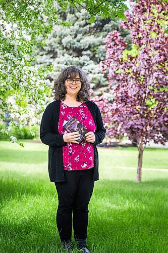 MIKAELA MACKENZIE / WINNIPEG FREE PRESS

Deborah Dykstra, founder and coordinator of the Next Chapter Book Club at Inclusion Winnipeg, poses for a portrait in her front yard with the book the club is currently reading in Winnipeg on Friday, May 29, 2020. The Next Chapter Book Club is a community-based book club open to everyone, including adolescents and adults with intellectual disabilities. For Aaron Epp story.
Winnipeg Free Press 2020.