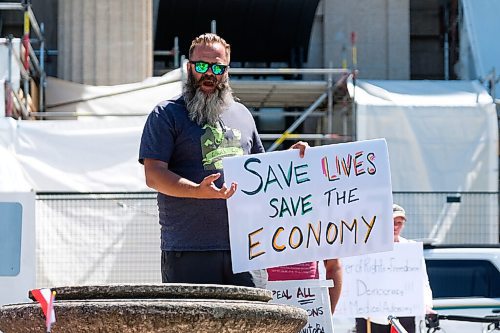 Daniel Crump / Winnipeg Free Press. An anti-lockdown protestors holds a sign as a small group gathers at the Manitoba Legislature. The group is calling for the removal of all coronavirus related lockdown restrictions. May 30, 2020.