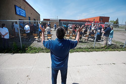 JOHN WOODS / WINNIPEG FREE PRESS
Darrell Morissette prays outside the fence as people hold a service outside in the parking lot at the Wide World of Faith Church Sunday, May 31, 2020. This is the first service they have been able to have since the COVID-19 lockdown.

Reporter: Standup or Rollason