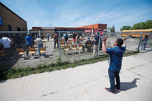 JOHN WOODS / WINNIPEG FREE PRESS
Darrell Morissette prays outside the fence as people hold a service outside in the parking lot at the Wide World of Faith Church Sunday, May 31, 2020. This is the first service they have been able to have since the COVID-19 lockdown.

Reporter: Standup or Rollason