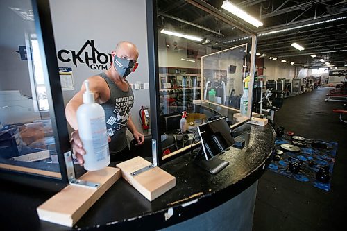 JOHN WOODS / WINNIPEG FREE PRESS
Paul Taylor, owner of Brickhouse Gym, puts a sanitizer bottle on counter between plexiglass protectors on the reception desk as he prepares his gym for re-opening Sunday, May 31, 2020. He will be reducing capacity, cleaning equipment, staff will be masked, and many other things to follow Manitoba COVID-19 phase 2 requirements.

Reporter: Rollason