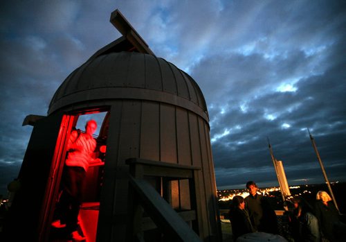 Brandon Sun Justin Moes (interior) walks by the new 16-inch telescope topping Brandon University's McMaster Hall during an opening ceremony at the facility's observatory, Wednesday evening. The new scope replaces the previous unit which served for almost 40 years, and is coupled with a device allowing real-time electronic imaging of faraway objects. The combination allows for original astronomical research to be done in Brandon for the first time. (Colin Corneau/Brandon Sun)