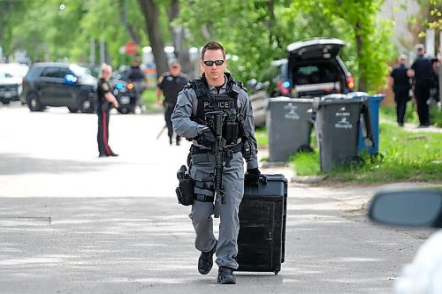 Daniel Crump / Winnipeg Free Press. A WPS Tactical Unit member carries equipment to a vehicle. Winnipeg Police Service block off a section of road in the 300 block of Aberdeen avenue. June 6, 2020.