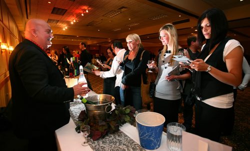 Brandon Sun Rod Biebrich of Aqua Vitae of Winnipeg, left, serves up a pink wine that he claims  "makes the ladies says "wow" during the 5th Annual Westman Wine Festival at the Royal Oak Inn on Friday evening. The event, sponsored by the Rotary Club of Brandon, will benefit the Elspeth Reid Family Resource Centre. (Bruce Bumstead/Brandon Sun)