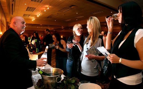 Brandon Sun Rod Biebrich of Aqua Vitae of Winnipeg, left, serves up a pink wine that he claims  "makes the ladies says "wow" during the 5th Annual Westman Wine Festival at the Royal Oak Inn on Friday evening. The event, sponsored by the Rotary Club of Brandon, will benefit the Elspeth Reid Family Resource Centre. (Bruce Bumstead/Brandon Sun)