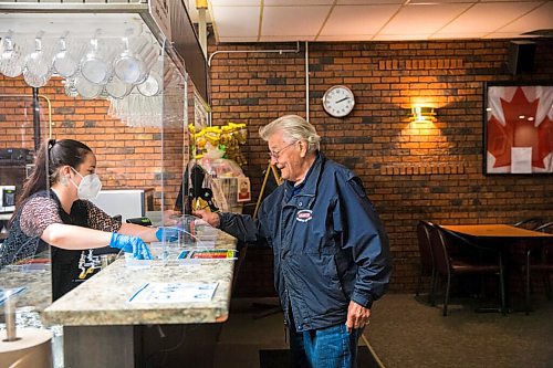 MIKAELA MACKENZIE / WINNIPEG FREE PRESS

Bartender Kate Fitzmaurice serves Ralph Moan, long-time regular, at the South Osborne Royal Legion on re-opening day in Winnipeg on Tuesday, June 9, 2020. For Randall King story.
Winnipeg Free Press 2020.